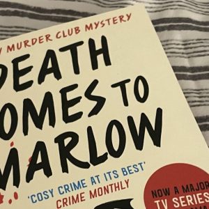 Death comes to Marlow book on a striped bed